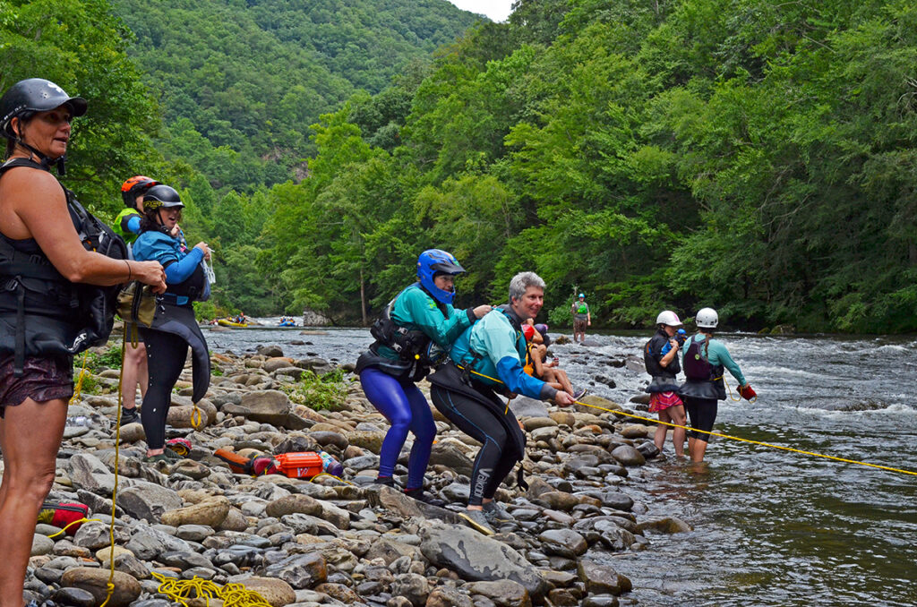 Females helping each other in a whitewater throw rope situation